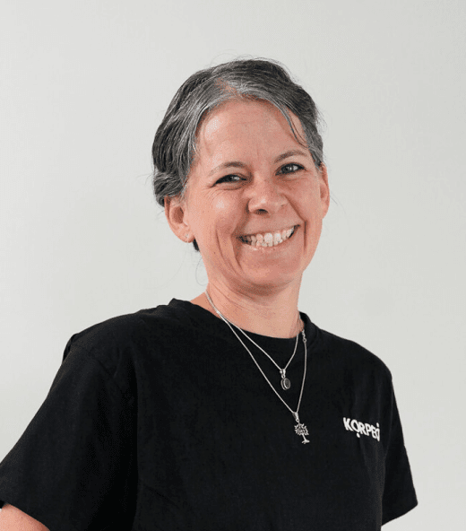 Lächelnde Mitarbeiterin im Korpeo-T-Shirt – freundliches Teammitglied im Empfangsbereich.