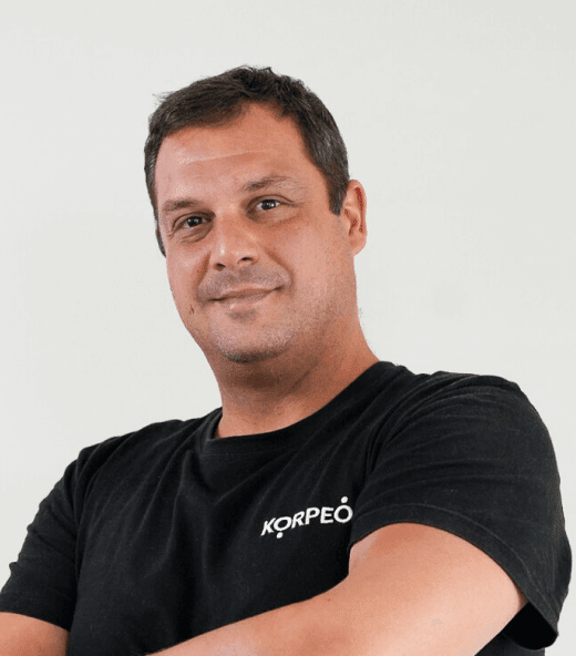 Lächelnder Mitarbeiter im Korpeo-T-Shirt – freundliches Teammitglied in der Physiotherapie.