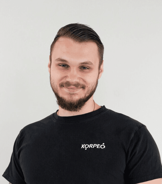 Lächelnder Mitarbeiter im Korpeo-T-Shirt – freundliches Teammitglied im Trainings- & Fitnessbereich.