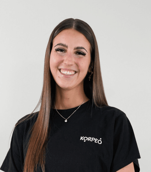 Lächelnde Mitarbeiterin im Korpeo-T-Shirt – freundliches Teammitglied im Trainings- & Fitnessbereich.