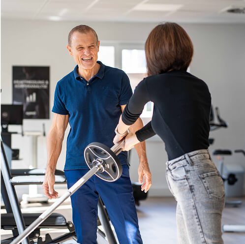 Physiotherapeut betreut aktives Krafttraining im Gesundheits- und Trainingszentrum.
