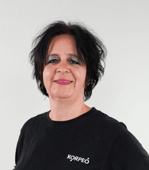 Lächelnde Mitarbeiterin im Korpeo-T-Shirt – freundliches Teammitglied in der Physiotherapie.