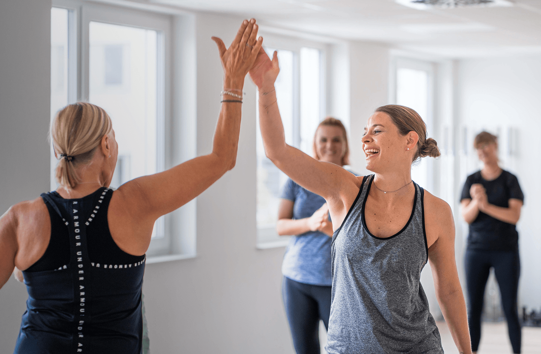 Frau lächelt in die Kamera und hat Spaß an der Bewegung, während eines Fitnesskurses in Wetzlar – freundliche Atmosphäre und Spaß an Bewegung bei Korpeo.