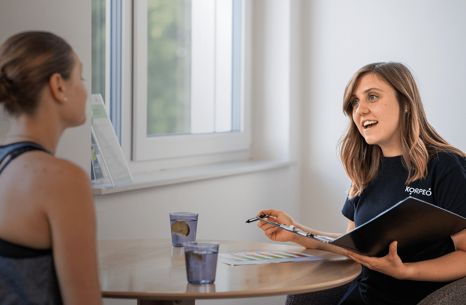 Ernährungsberaterin im Gespräch mit Klemmbrett – individuelle Gesundheitsberatung im Fitnessstudio Aßlar.