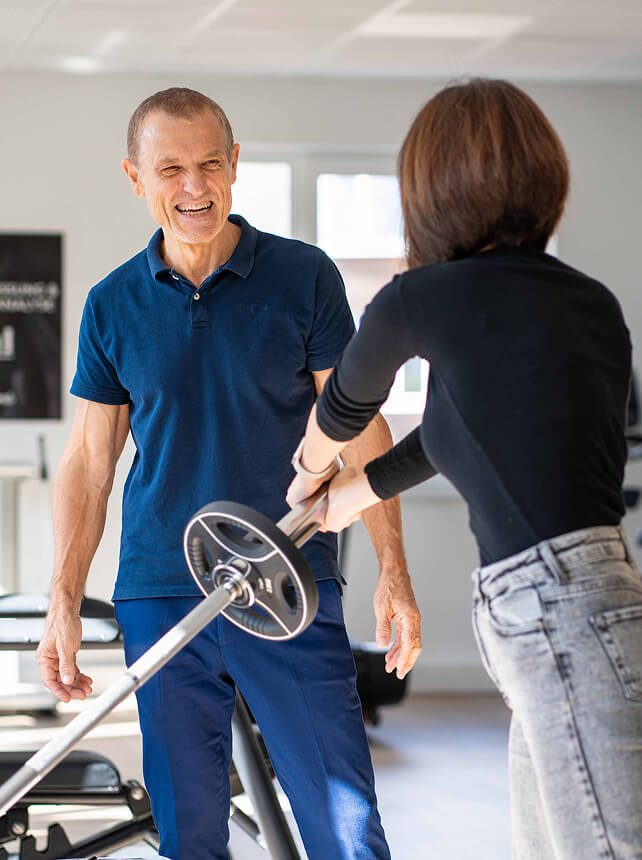 Physiotherapeut betreut Training mit Langhantel – praxisnahe Weiterbildungsmöglichkeiten im Rahmen der Karriere Physiotherapie.