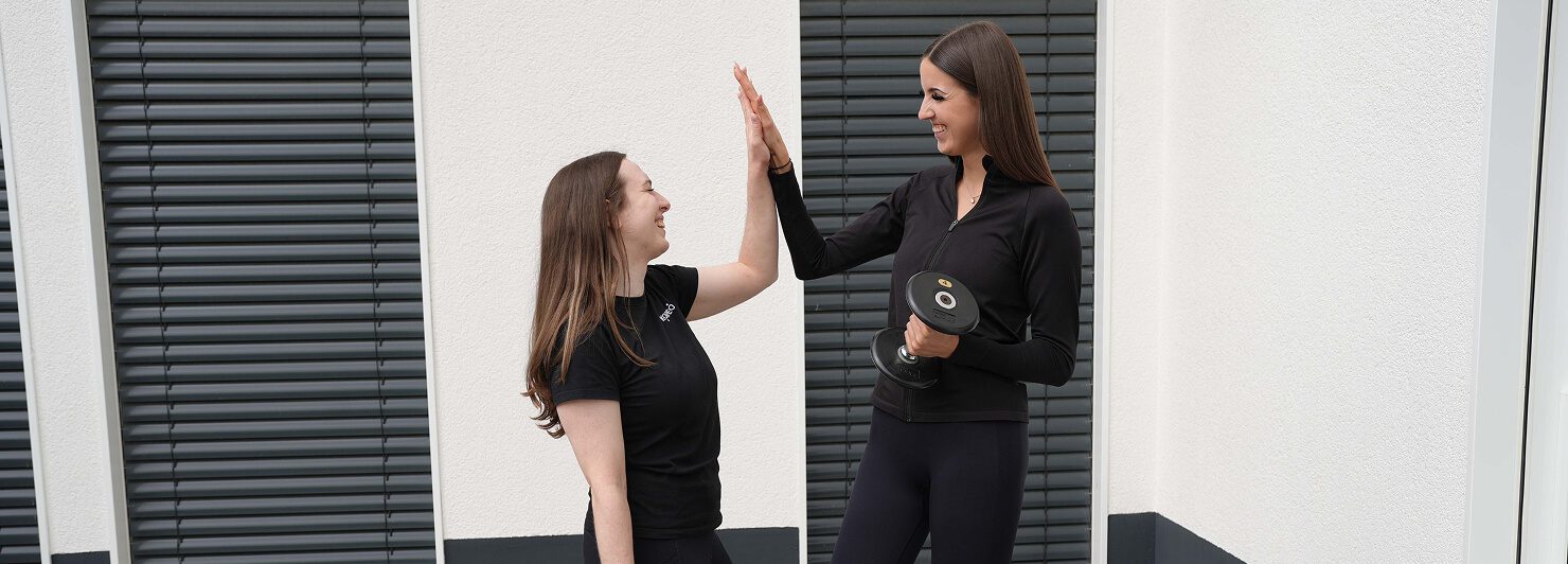 Zwei Personen beim gemeinsamen Training – freundschaftliches Miteinander und Teamgeist als Teil der Karriere in der Physiotherapie.