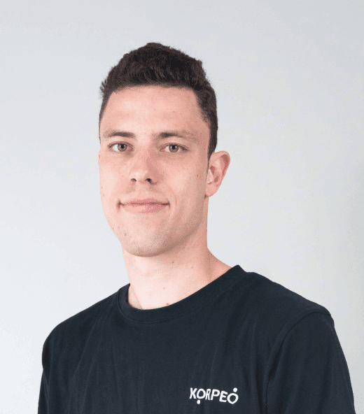 Lächelnder Mitarbeiter im Korpeo-T-Shirt – freundliches Teammitglied in der Physiotherapie.