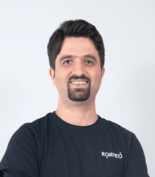 Lächelnder Mitarbeiter im Korpeo-T-Shirt – freundliches Teammitglied in der Physiotherapie.