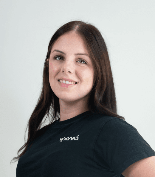 Lächelnde Mitarbeiterin im Korpeo-T-Shirt – freundliches Teammitglied im Trainings- & Fitnessbereich.