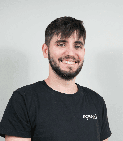 Lächelnder Mitarbeiter im Korpeo-T-Shirt – freundliches Teammitglied in der Physiotherapie.