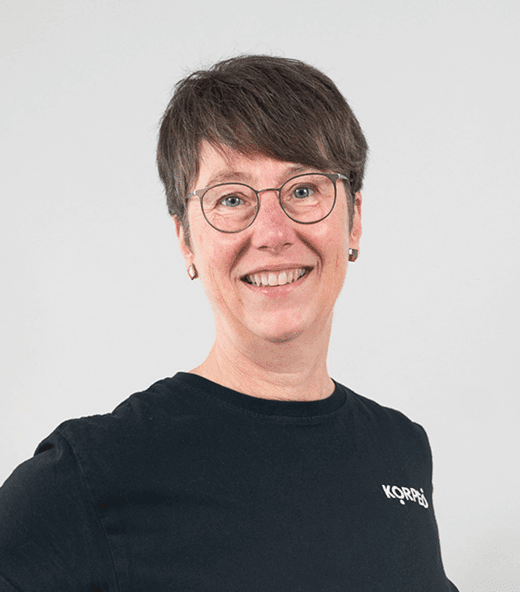 Lächelnde Mitarbeiterin im Korpeo-T-Shirt – freundliches Teammitglied im Empfangsbereich.