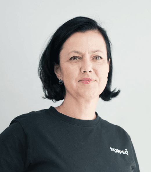 Lächelnde Mitarbeiterin im Korpeo-T-Shirt – freundliches Teammitglied in der Physiotherapie.