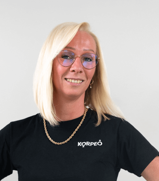 Lächelnde Mitarbeiterin im Korpeo-T-Shirt – freundliches Teammitglied im Empfangsbereich.