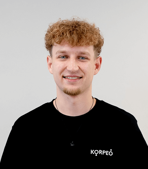 Lächelnder Mitarbeiter im Korpeo-T-Shirt – freundliches Teammitglied in der Physiotherapie.