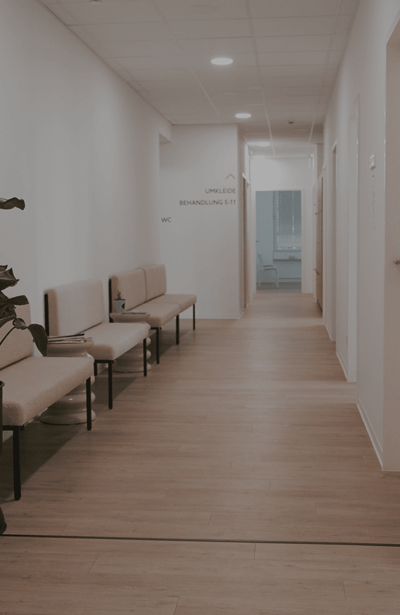 Moderner Flur bei Korpeo Offenbach mit stilvollen Sitzbänken, grünen Pflanzen und heller, einladender Einrichtung – angenehme Atmosphäre im Praxisbereich.