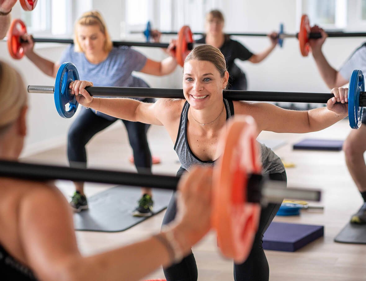 Funktionelles Gruppentraining mit Kniebeugen – aktives Leistungsangebot der Physiotherapie zur Förderung von Beweglichkeit.