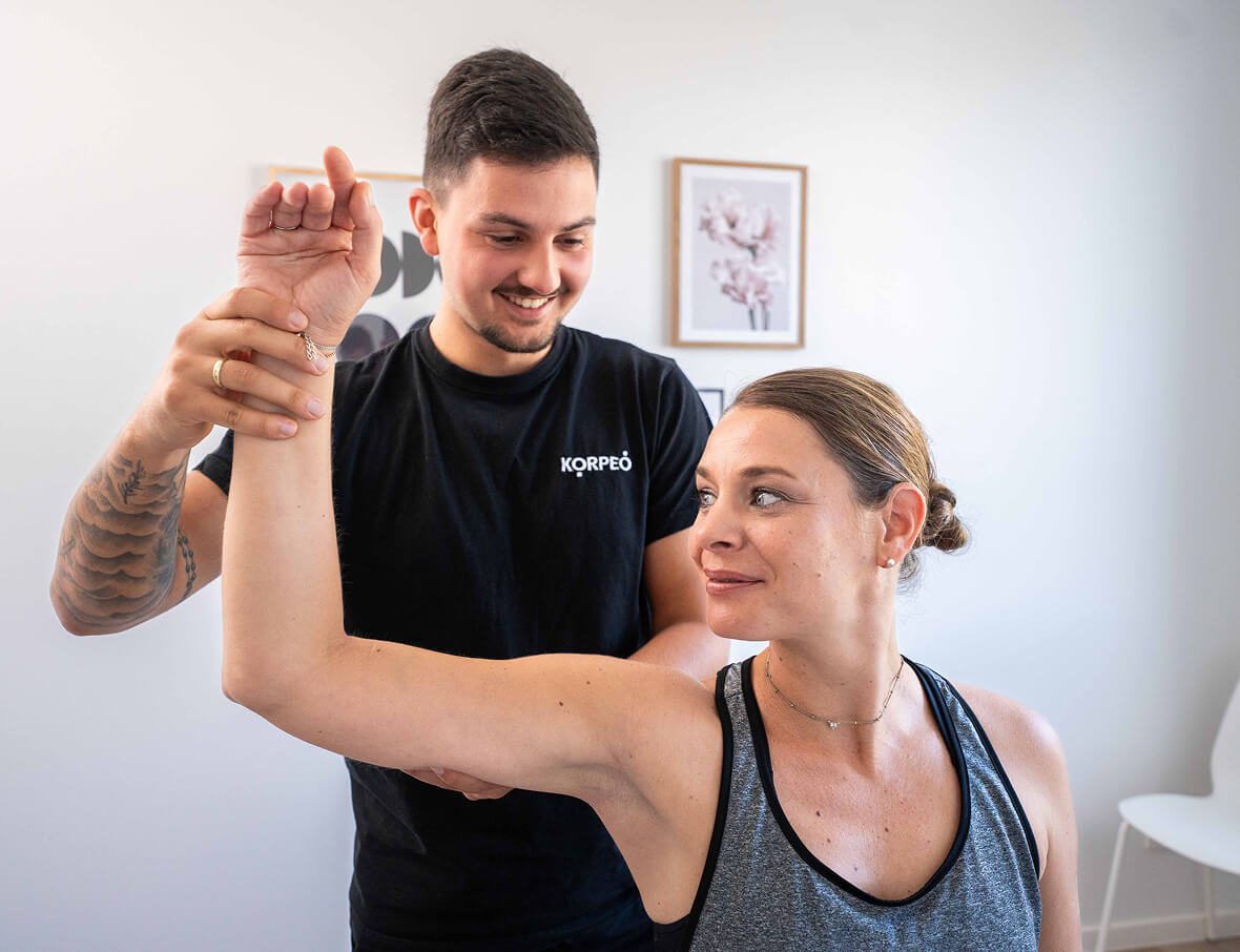 Mann und Frau führen gemeinsam Übungen im Rahmen einer Physiotherapiesitzung durch – gezielte Bewegungstherapie mit Fokus auf Teamarbeit und Rehabilitation.