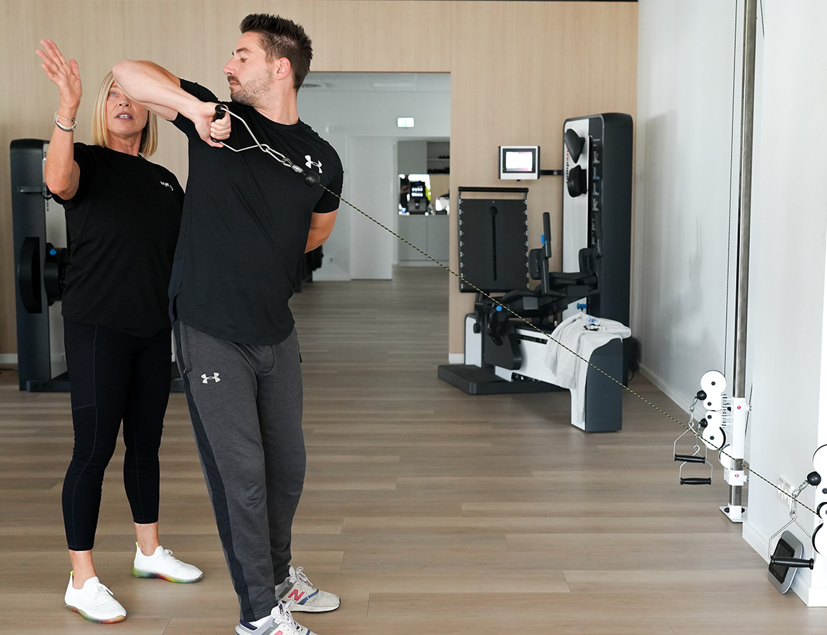 Mann beim EAP Training in Anleitung durch eine Physiotherapeutin