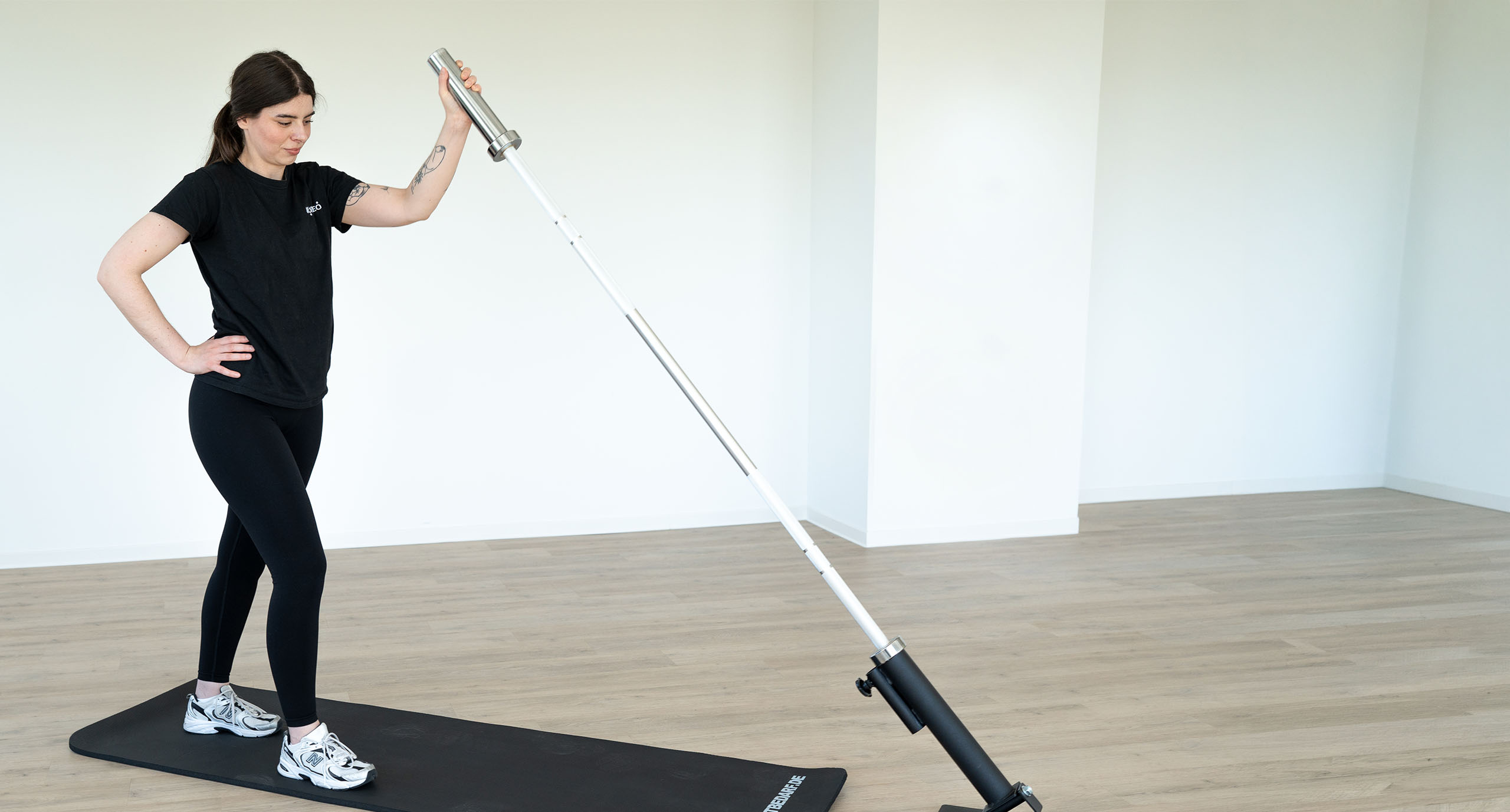 Junge Frau trainiert mit einer Barbell Rotation im Kursraum in Großkrotzenburg