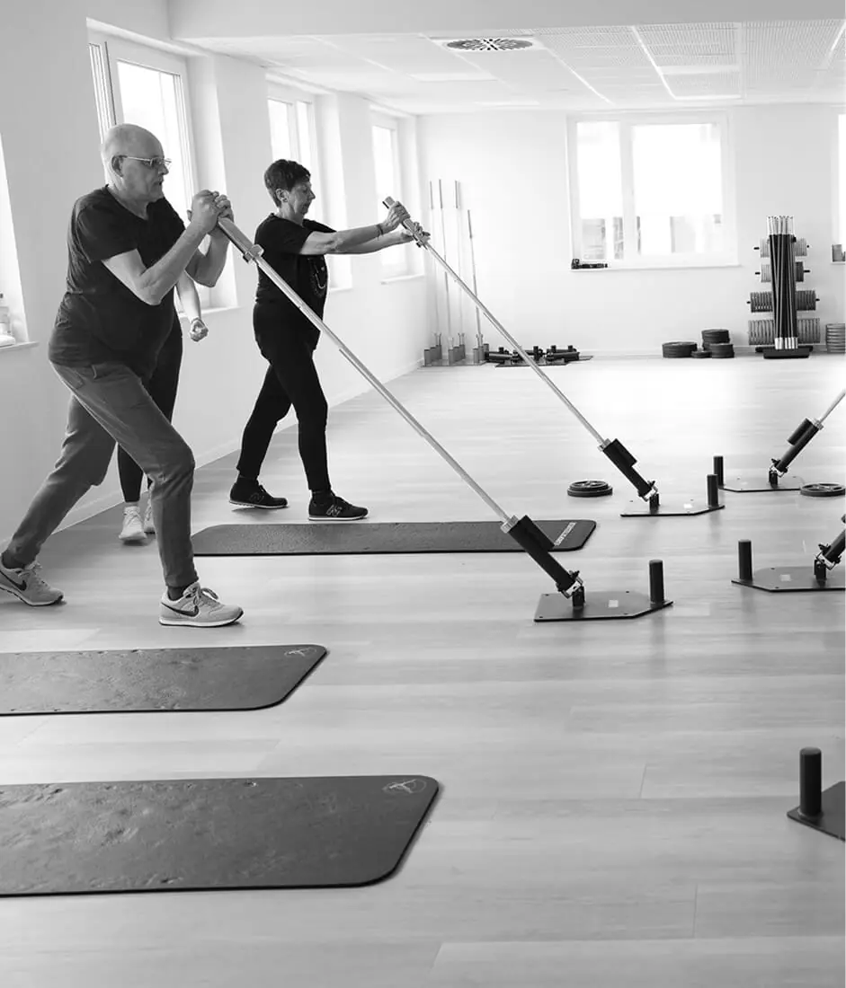 Gruppe Fitness-Enthusiasten trainiert gemeinsam mit Langhanteln – Teamwork und Motivation in Kursen in meiner Nähe.