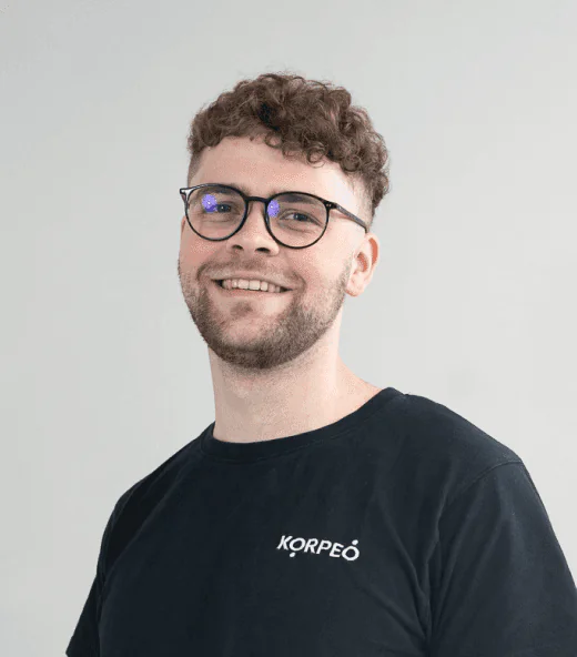 Lächelnder Mitarbeiter im Korpeo-T-Shirt – freundliches Teammitglied in der Physiotherapie.