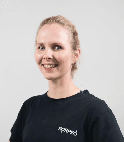 Lächelnde Mitarbeiterin im Korpeo-T-Shirt – freundliches Teammitglied in der Physiotherapie.