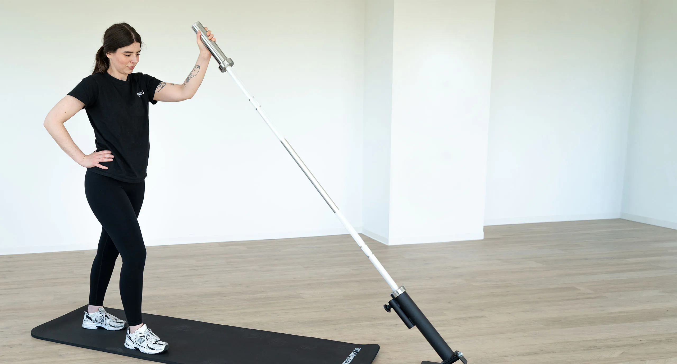 Junge Frau trainiert mit einer Barbell Rotation im Kursraum in Großkrotzenburg